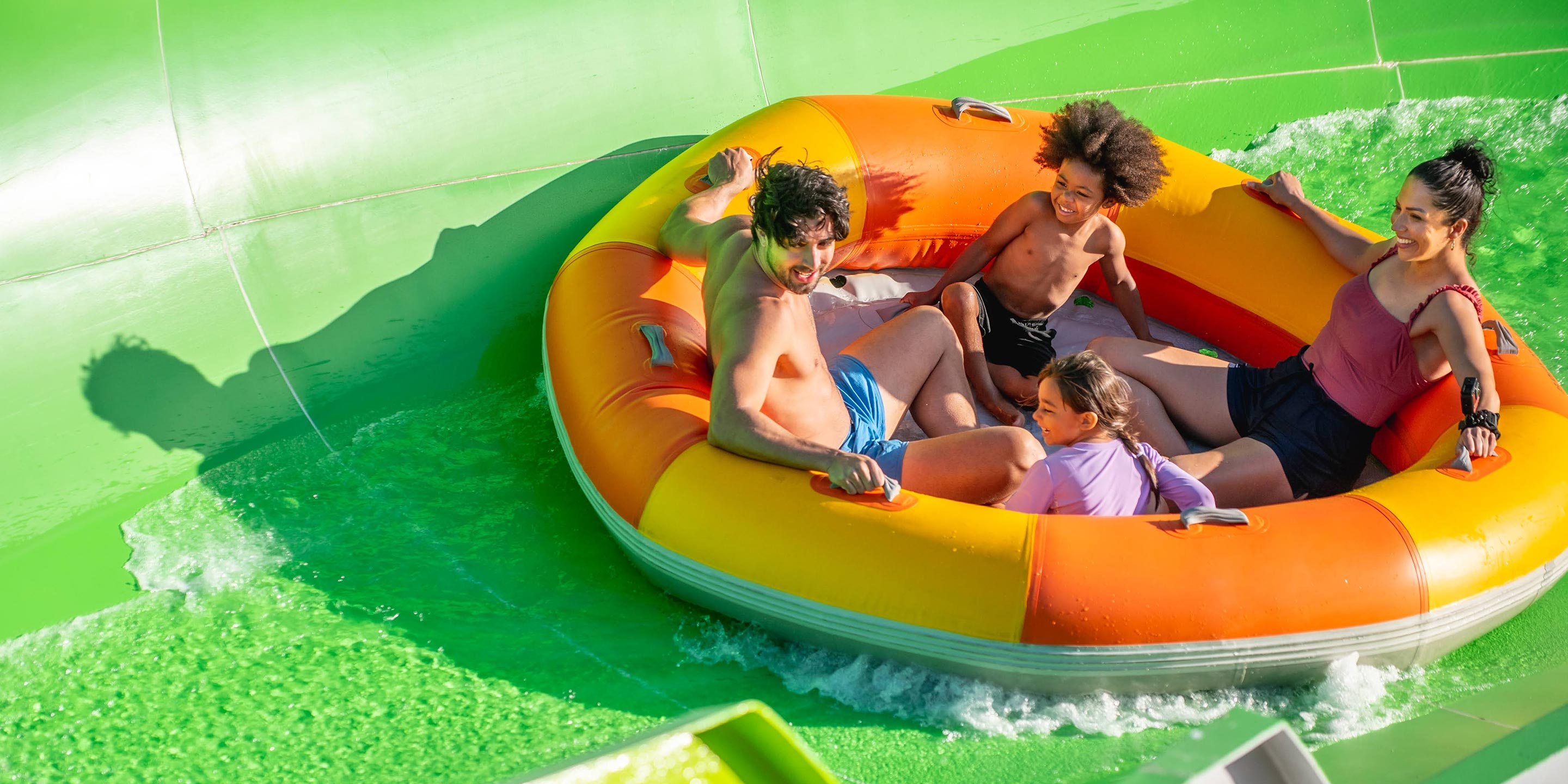 A family together in a raft on the Oscar's Rotten Rafts water ride