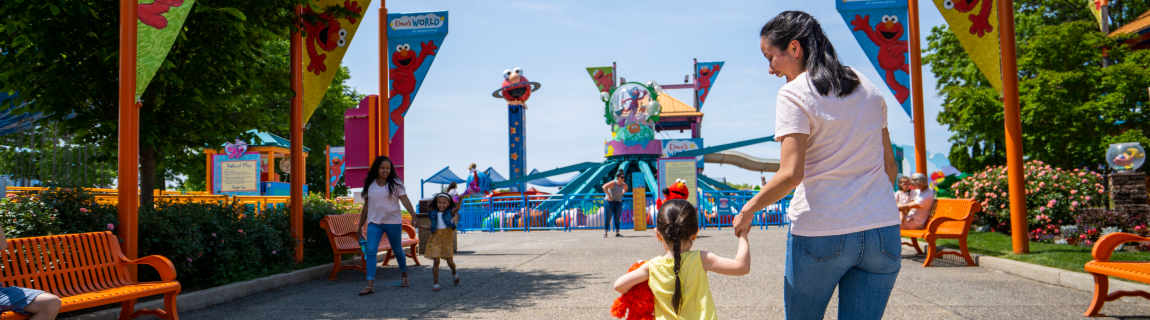 A mother and child walking in the Sesame Place Philadelphia park