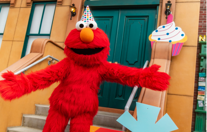 Elmo with a cupcake and birthday hat.
