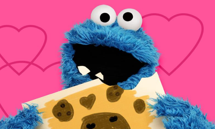 Cookie Monster with cookie and hearts in background.