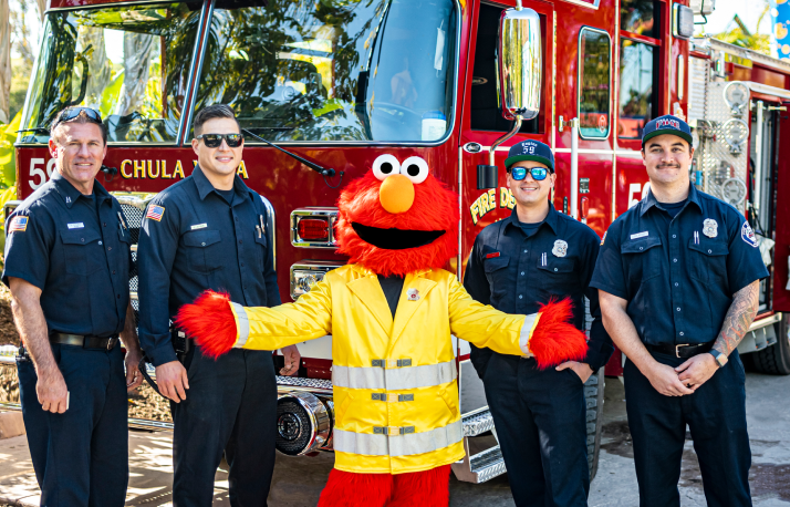 Elmo with firemen.